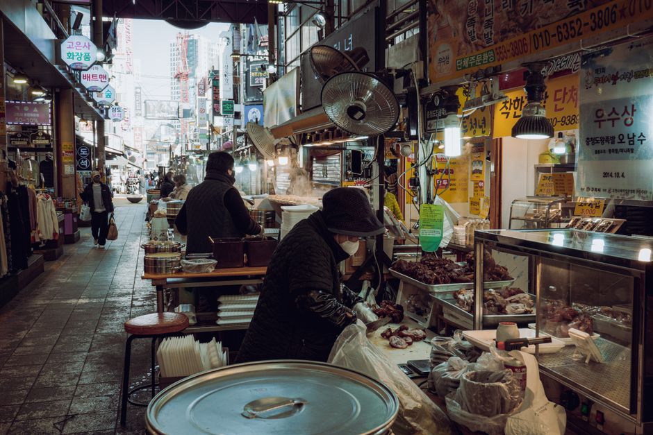A bustling market scene in Guri-si, showcasing local vendors selling food and goods.